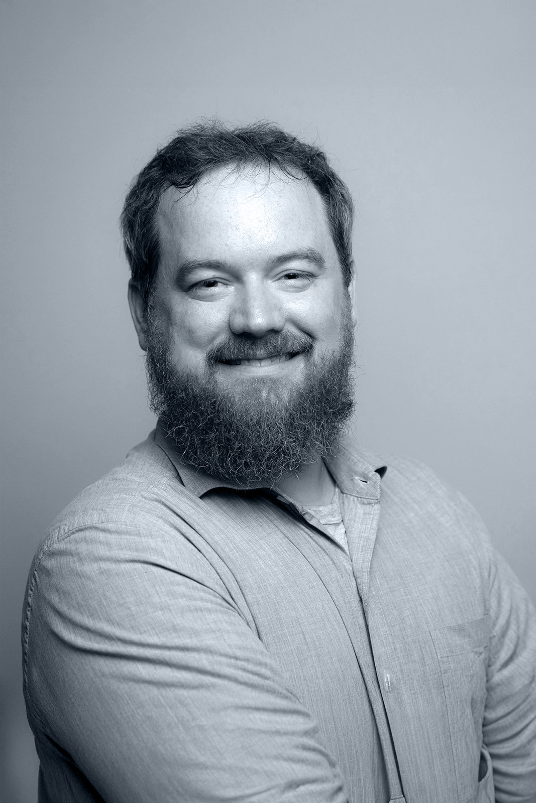 Portrait of John Markey smiling against a dark background